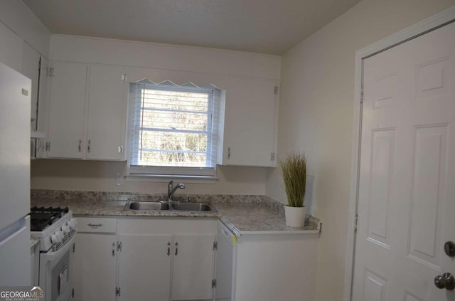 kitchen featuring light countertops, white appliances, white cabinets, and a sink