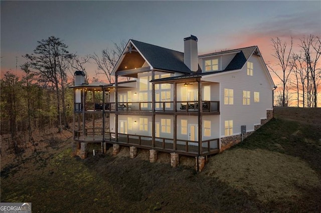 back of house with a deck and a chimney