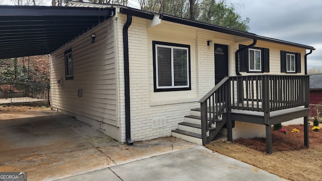 view of front of house with concrete driveway, brick siding, crawl space, and an attached carport