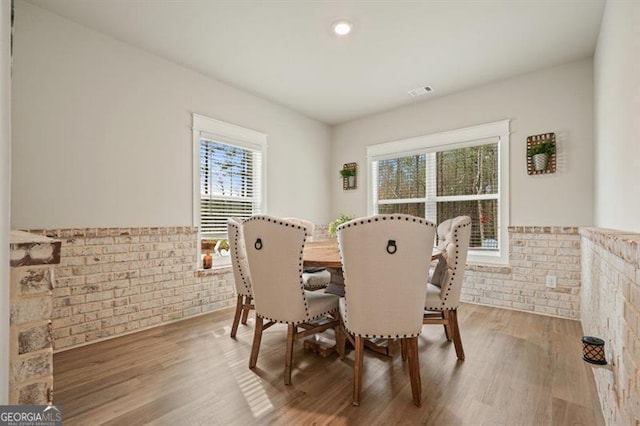 1312 Mcgarity Rd, Temple, GA 30179 - dining room featuring plenty of natural light, wood finished floors, a wainscoted wall, and brick wall