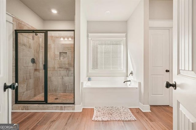 1312 Mcgarity Rd, Temple, GA 30179 - bathroom with a garden tub, a shower stall, wood finished floors, and baseboards