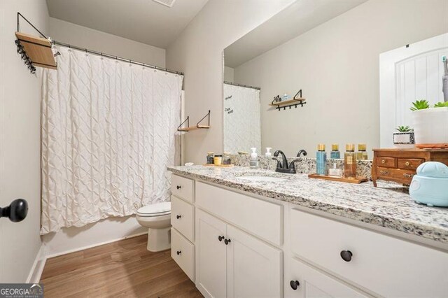 1312 Mcgarity Rd, Temple, GA 30179 - bathroom with wood finished floors, toilet, vanity, shower / tub combo, and baseboards
