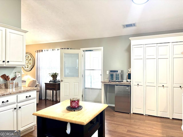 kitchen featuring white cabinets, visible vents, dark wood finished floors, and fridge