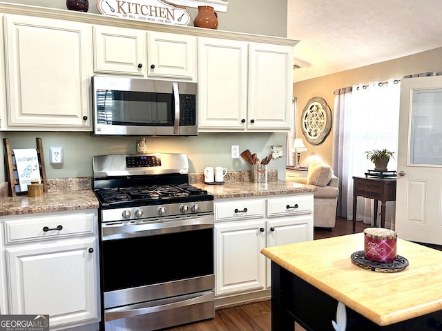 kitchen with white cabinets, dark wood-style floors, and stainless steel appliances