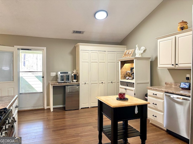 kitchen with visible vents, dark wood finished floors, lofted ceiling, appliances with stainless steel finishes, and light countertops