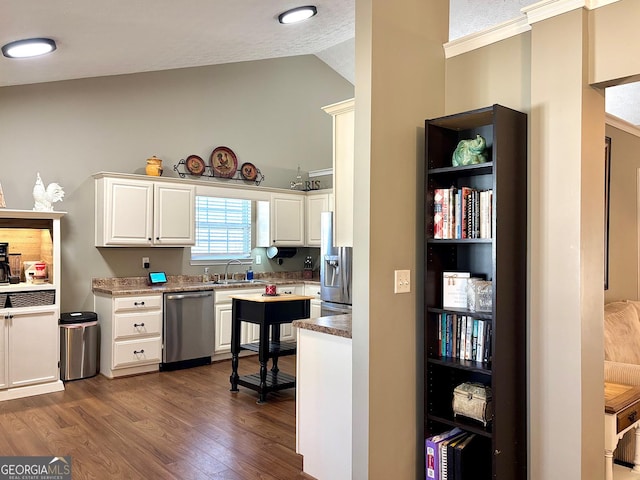 kitchen featuring dark wood-style floors, stainless steel appliances, lofted ceiling, white cabinetry, and a sink