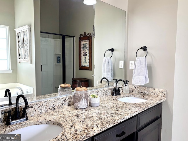 bathroom featuring double vanity, a stall shower, and a sink