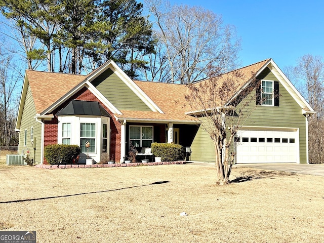 view of front of house with brick siding, roof with shingles, central AC unit, a garage, and driveway