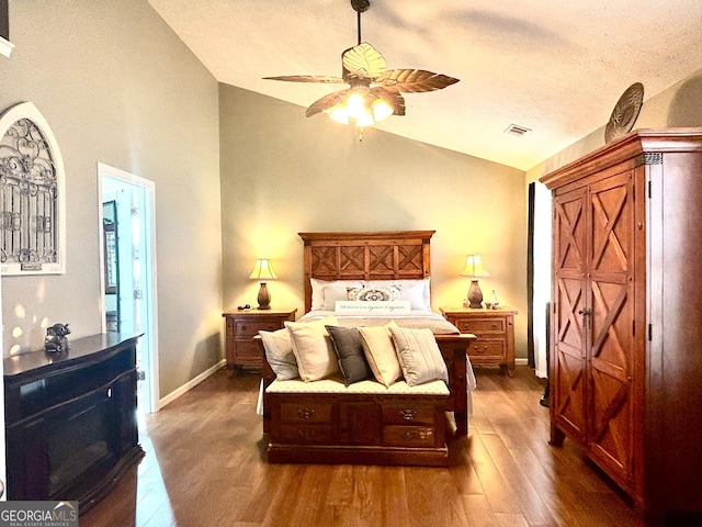 bedroom featuring a textured ceiling, baseboards, vaulted ceiling, and dark wood finished floors