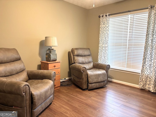 sitting room featuring a textured ceiling, baseboards, and wood finished floors