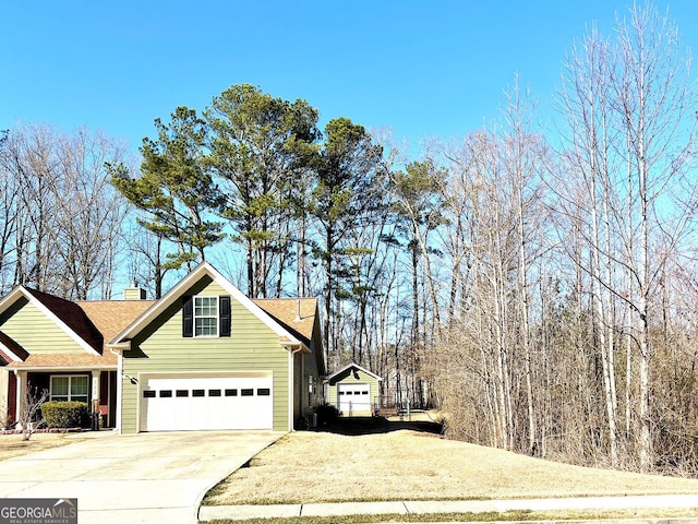 view of property exterior with concrete driveway, a chimney, and an attached garage