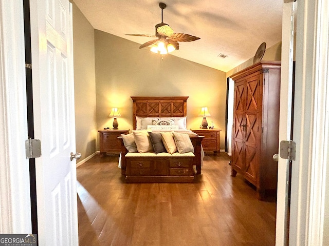 bedroom featuring lofted ceiling, visible vents, dark wood-type flooring, ceiling fan, and baseboards