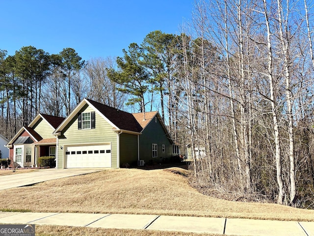 view of side of property with a garage and concrete driveway