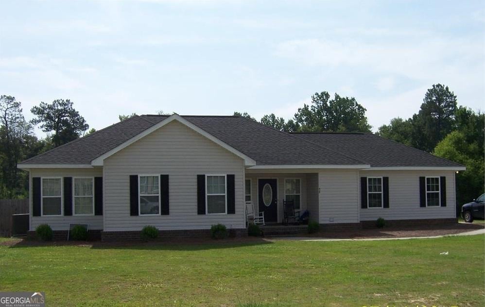 ranch-style house featuring a front yard and roof with shingles