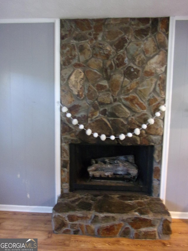 details with a fireplace, wood finished floors, and baseboards