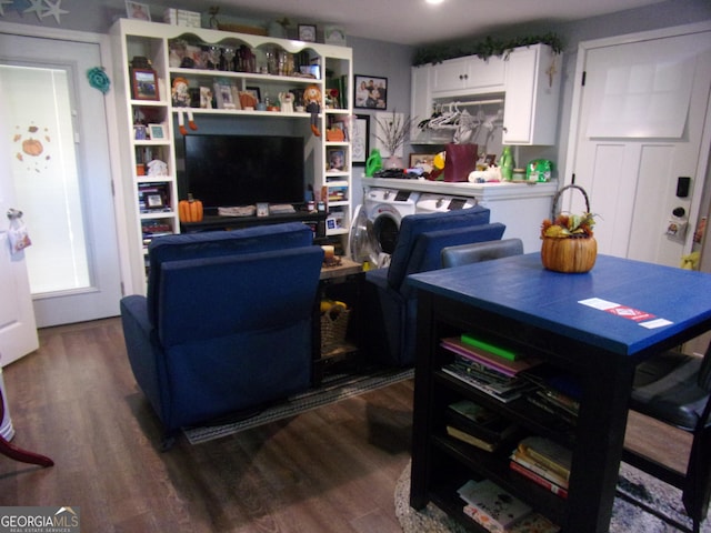 living area with dark wood-style floors and washer / dryer