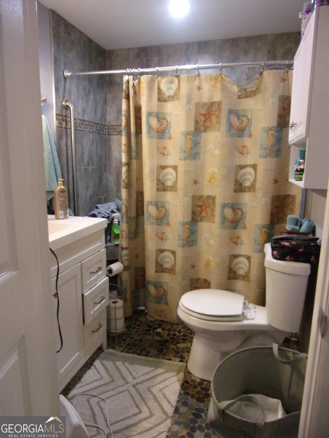 bathroom with toilet, a shower with shower curtain, and vanity