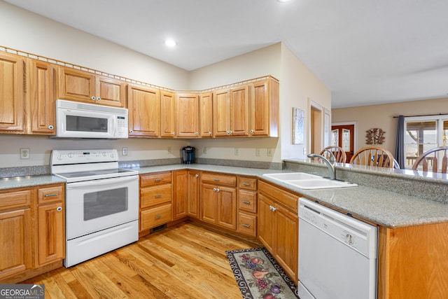 kitchen with light wood-style flooring, recessed lighting, a peninsula, white appliances, and a sink