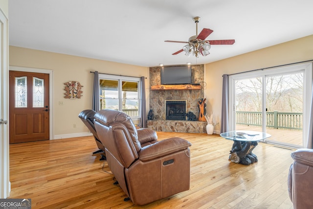 living area featuring a fireplace, plenty of natural light, and light wood-style flooring