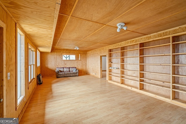 unfurnished room with built in shelves, wood walls, wood finished floors, and wood ceiling