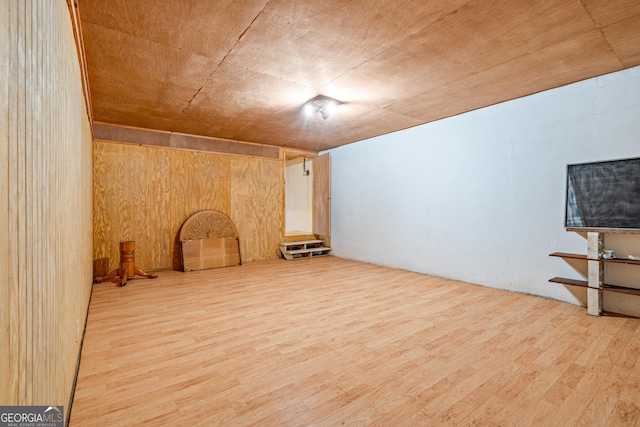 unfurnished room with wooden walls and wood finished floors