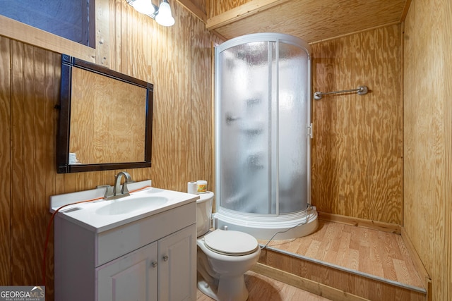 full bath with toilet, wood finished floors, vanity, wood walls, and a shower stall