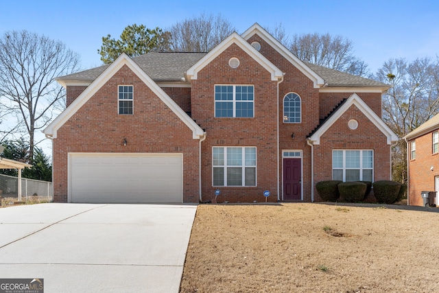 traditional-style home with driveway, brick siding, and an attached garage