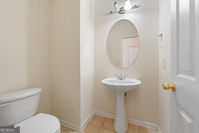 bathroom featuring tile patterned flooring, toilet, and baseboards