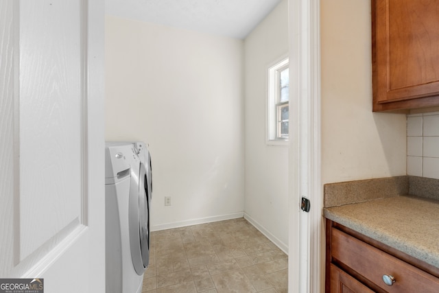 clothes washing area with washer and clothes dryer and baseboards