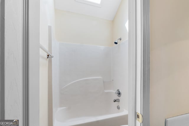 bathroom featuring a skylight and shower / washtub combination