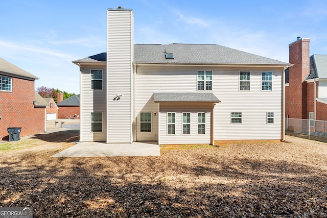 back of property featuring a patio area, fence, a chimney, and roof with shingles