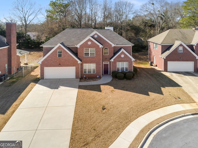 traditional home featuring driveway, a garage, roof with shingles, fence, and brick siding