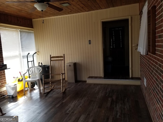 property entrance with a ceiling fan and brick siding
