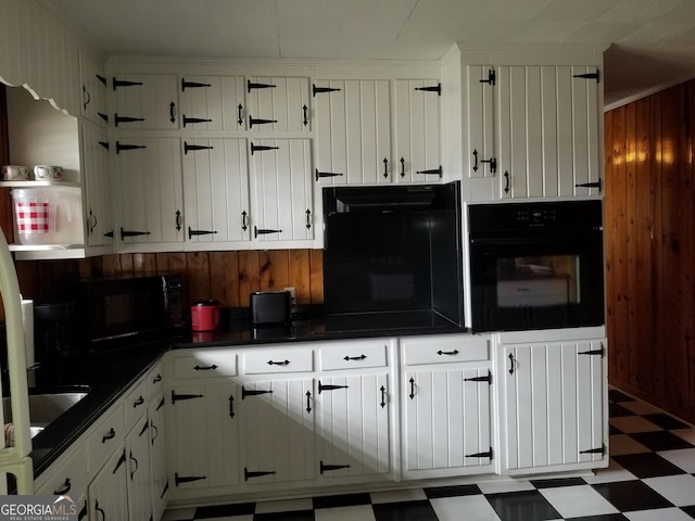 kitchen featuring dark countertops, white cabinets, black appliances, and tile patterned floors