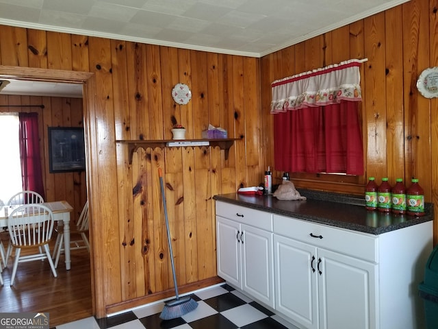 interior space featuring crown molding, wood walls, and tile patterned floors