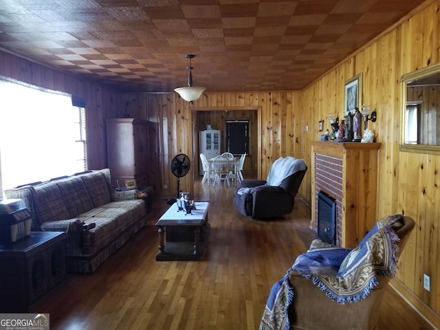 living area with a fireplace, wooden walls, and wood finished floors