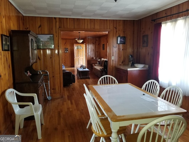 dining area with wood walls and wood finished floors