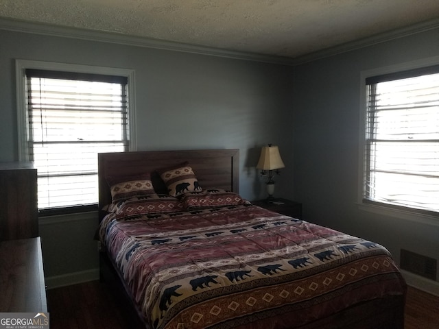 bedroom featuring baseboards, visible vents, ornamental molding, and a textured ceiling