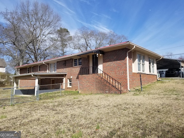 exterior space with a carport, brick siding, a front yard, and fence