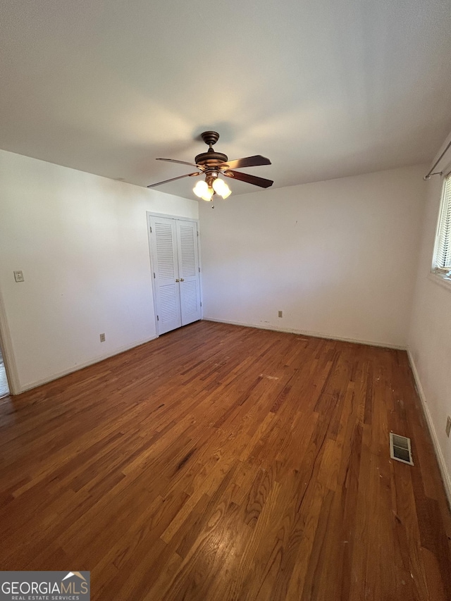 unfurnished bedroom with a ceiling fan, visible vents, and wood finished floors