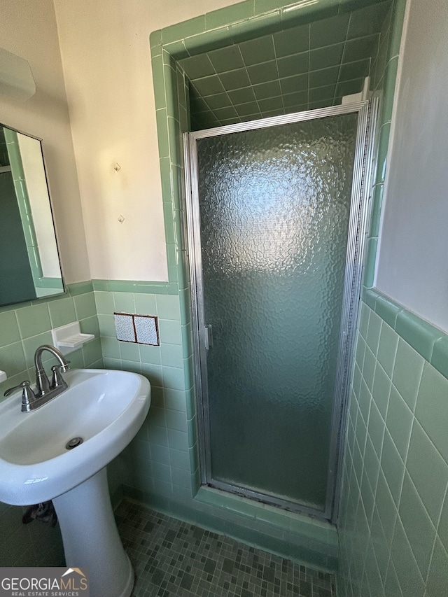 full bath featuring a shower stall, tile walls, and tile patterned floors