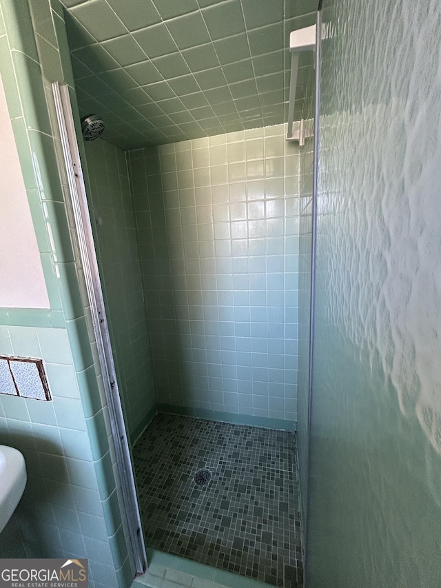 bathroom featuring a stall shower and tile walls