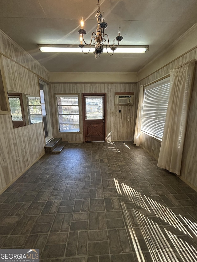interior space with brick floor, wooden walls, crown molding, and an inviting chandelier