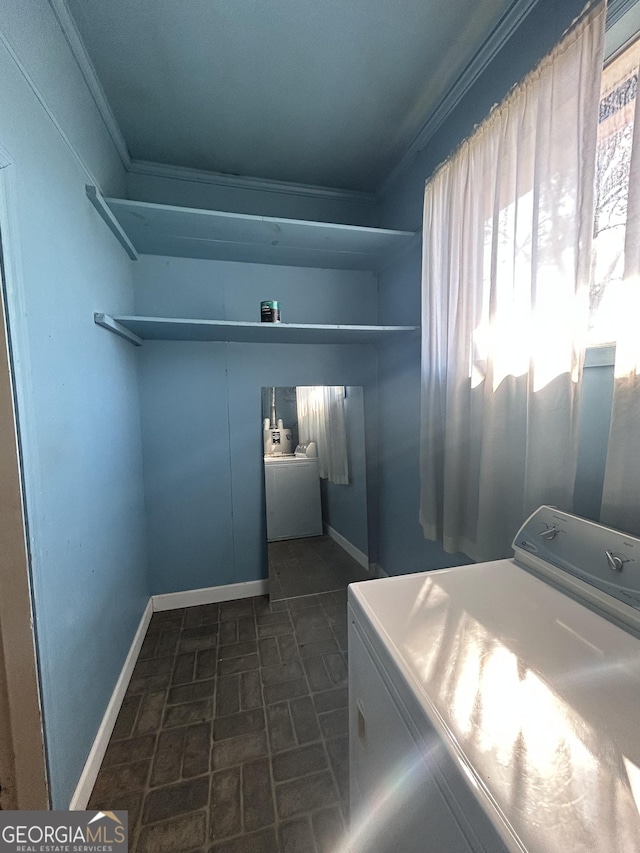 laundry area featuring ornamental molding, laundry area, baseboards, and washing machine and clothes dryer