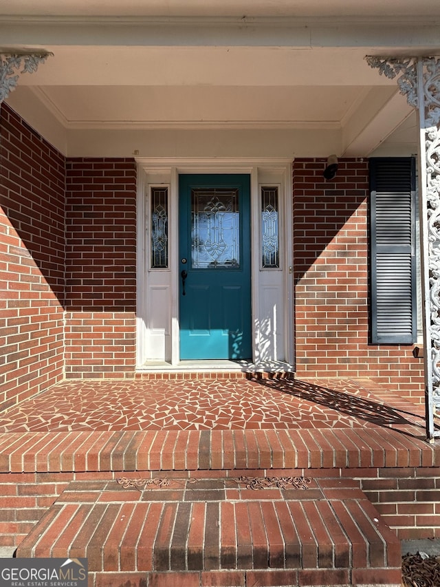 property entrance featuring brick siding