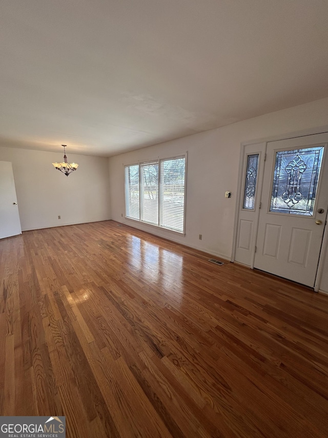 entryway featuring visible vents, a notable chandelier, and wood finished floors
