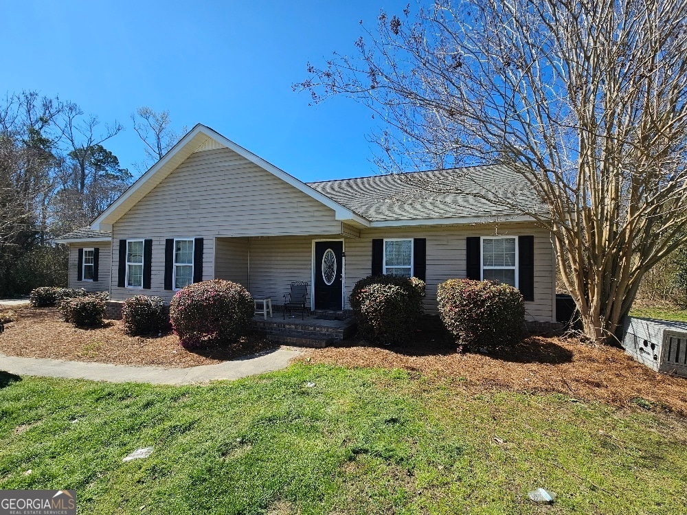 single story home featuring a front lawn