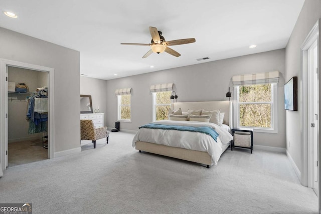 carpeted bedroom featuring baseboards, a spacious closet, multiple windows, and recessed lighting