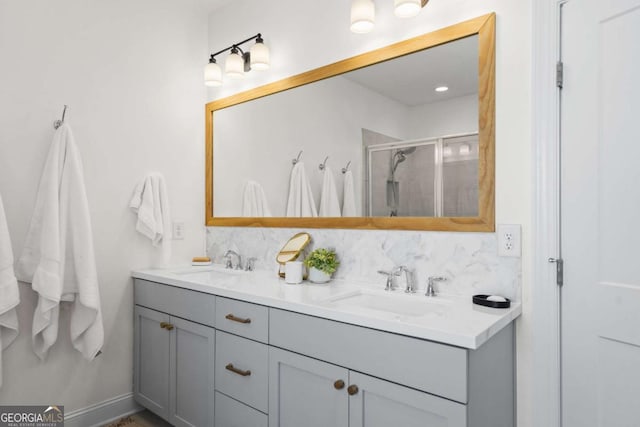 bathroom with a stall shower, backsplash, and a sink