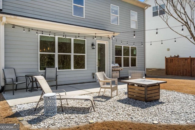 view of patio with an outdoor fire pit, fence, and area for grilling